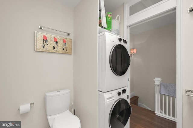 laundry room with stacked washer / dryer, laundry area, and dark wood finished floors