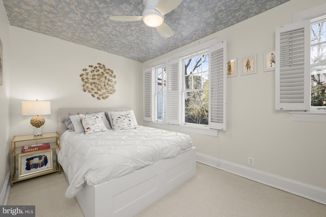 bedroom featuring ceiling fan, light colored carpet, and baseboards