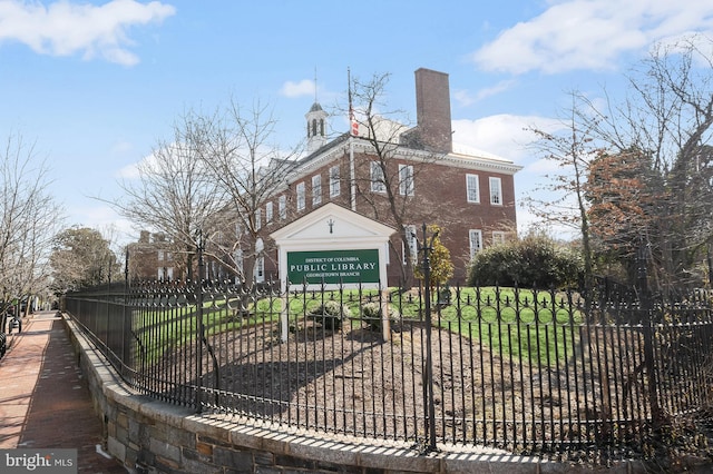 exterior space featuring a chimney, fence, and a front yard