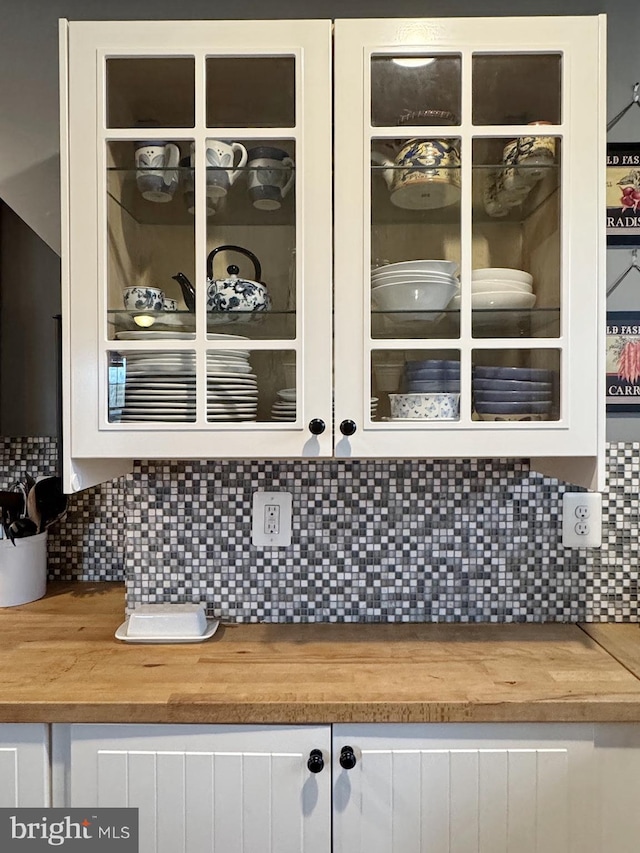 interior details featuring white cabinets, glass insert cabinets, and butcher block counters