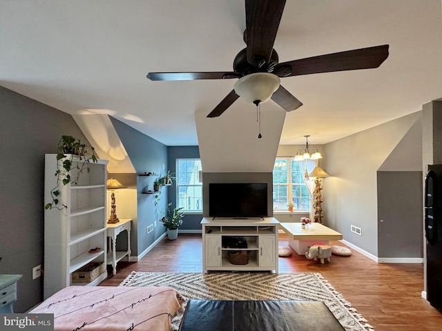 living area featuring a ceiling fan, baseboards, and wood finished floors