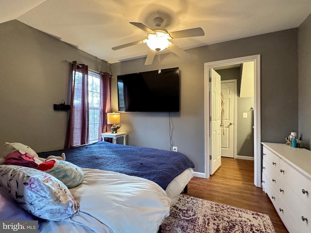 bedroom with ceiling fan, baseboards, and wood finished floors