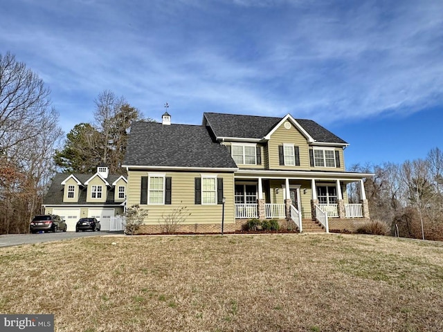 view of front facade with driveway, a porch, a front yard, a garage, and a chimney