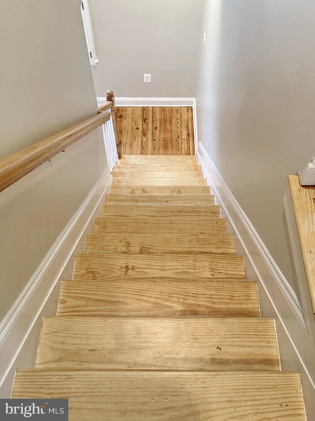 stairs featuring wood finished floors