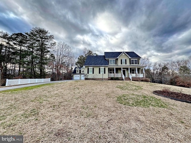 view of front of property featuring a front lawn, fence, covered porch, a garage, and driveway