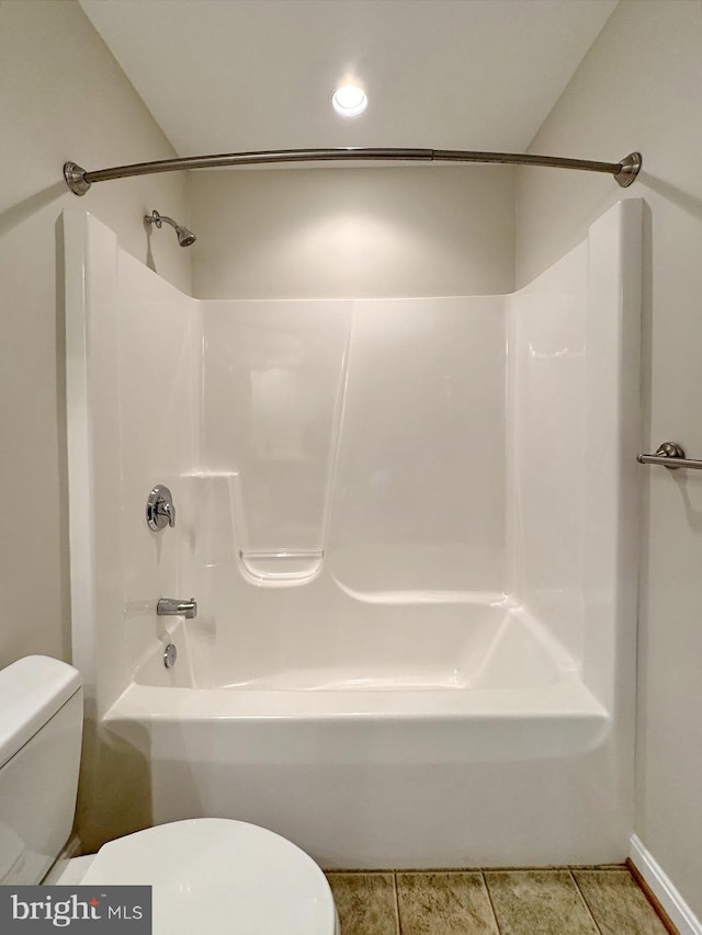 bathroom with toilet, shower / bathtub combination, and tile patterned flooring