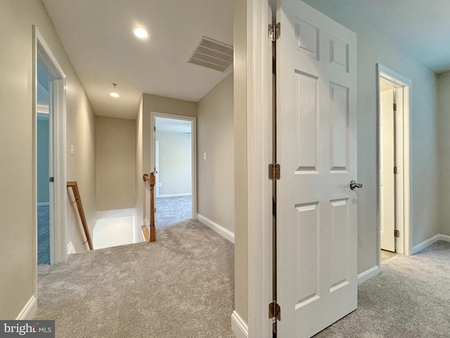 corridor featuring recessed lighting, visible vents, an upstairs landing, and carpet