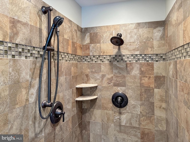 interior details featuring tiled shower