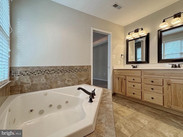 full bathroom featuring visible vents, a sink, a tub with jets, and double vanity