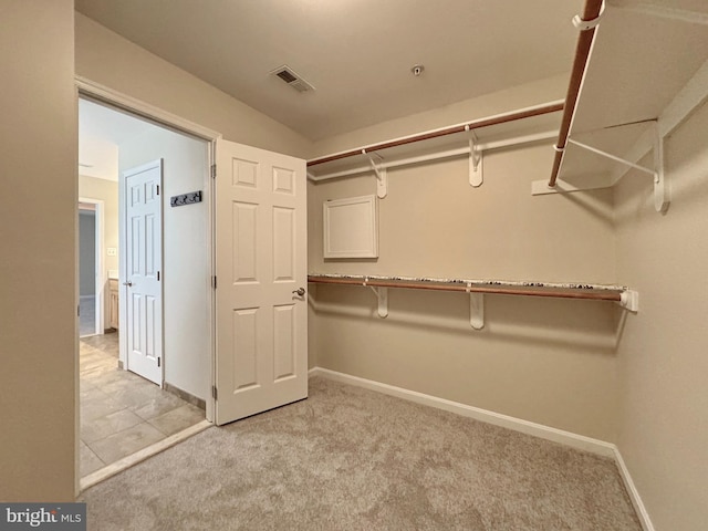 spacious closet featuring visible vents and light carpet