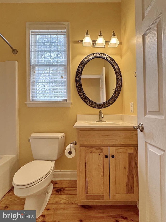 full bathroom featuring baseboards, toilet, shower / bath combination, wood finished floors, and vanity