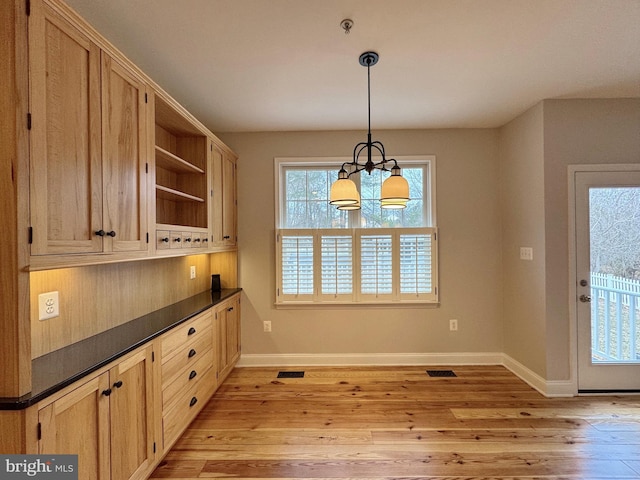 unfurnished dining area with visible vents, baseboards, and light wood-style flooring