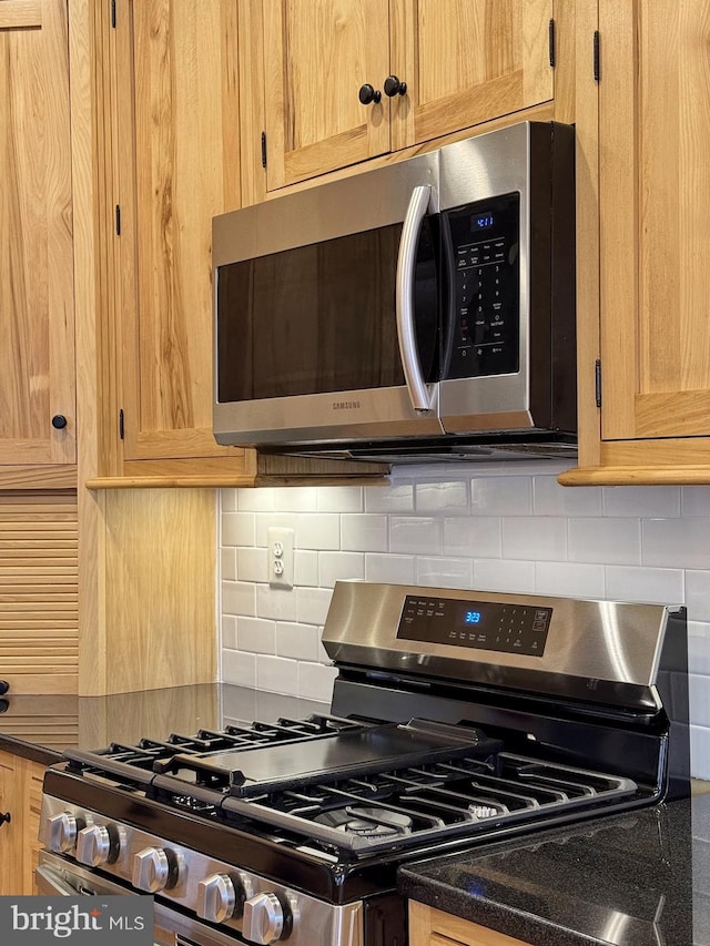 kitchen with dark countertops, decorative backsplash, and appliances with stainless steel finishes