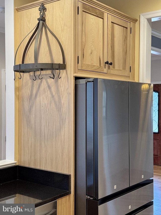 interior space featuring dark countertops, light brown cabinets, and freestanding refrigerator