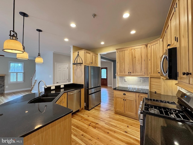 kitchen with light brown cabinets, light wood-style flooring, a sink, appliances with stainless steel finishes, and tasteful backsplash