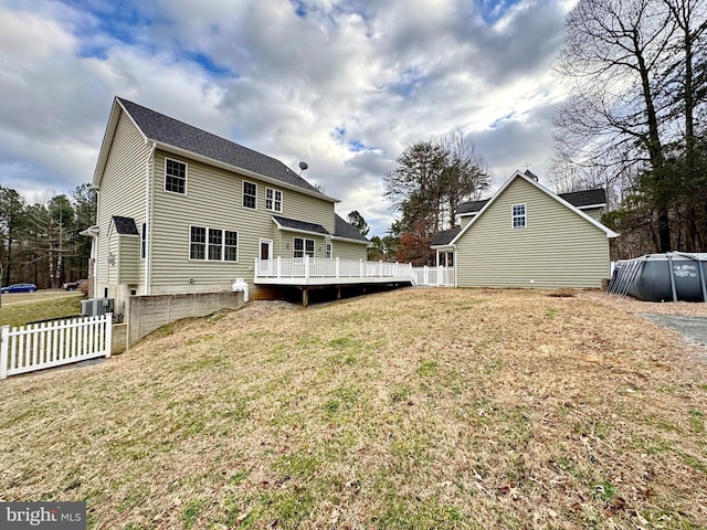 back of property featuring a yard, fence, and a wooden deck