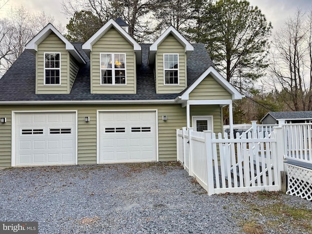 view of front facade featuring fence, a garage, and roof with shingles