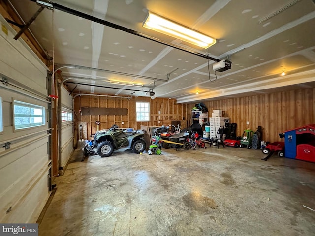 garage featuring wood walls and a garage door opener