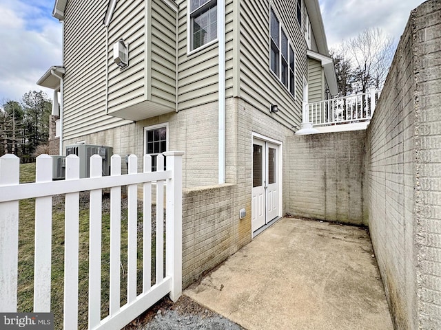 view of property exterior with brick siding and fence