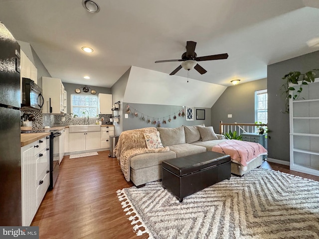 bedroom with a sink, dark wood-type flooring, baseboards, and vaulted ceiling