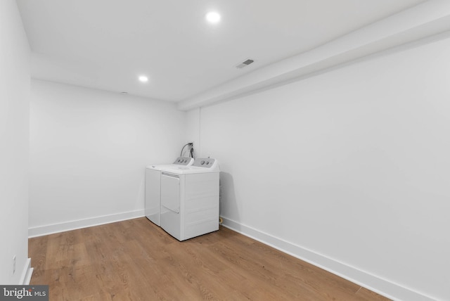 laundry room with washing machine and dryer, baseboards, wood finished floors, and recessed lighting