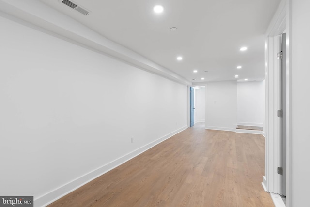 unfurnished room with recessed lighting, visible vents, light wood-style flooring, and baseboards