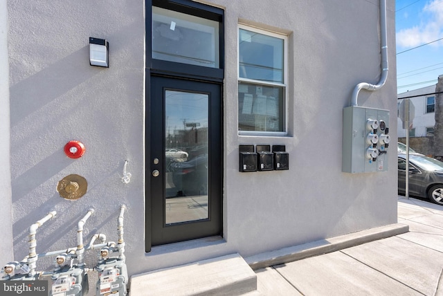 view of exterior entry featuring stucco siding