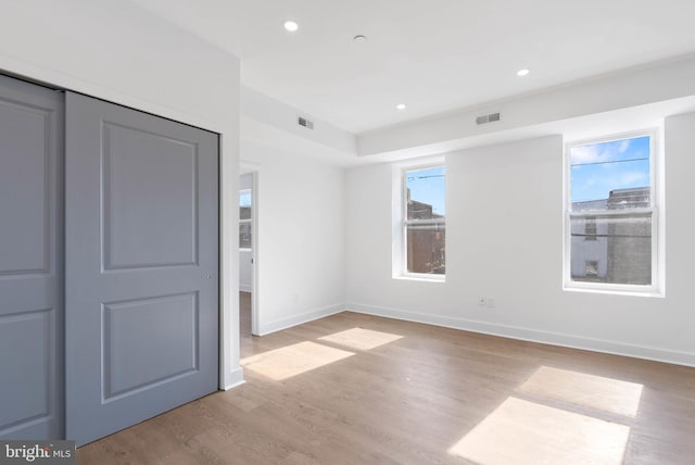 unfurnished bedroom featuring baseboards, light wood finished floors, visible vents, and recessed lighting