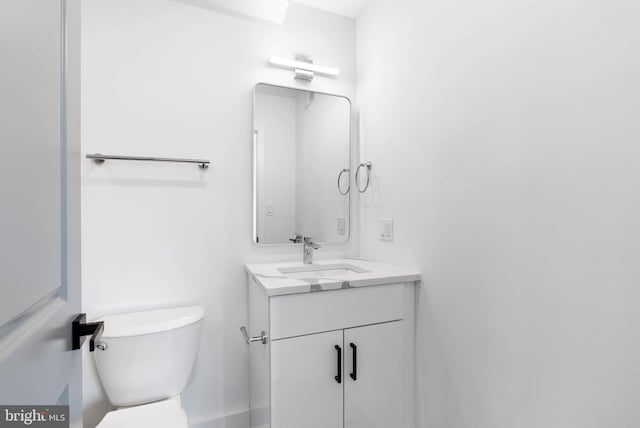 half bathroom with toilet and vanity