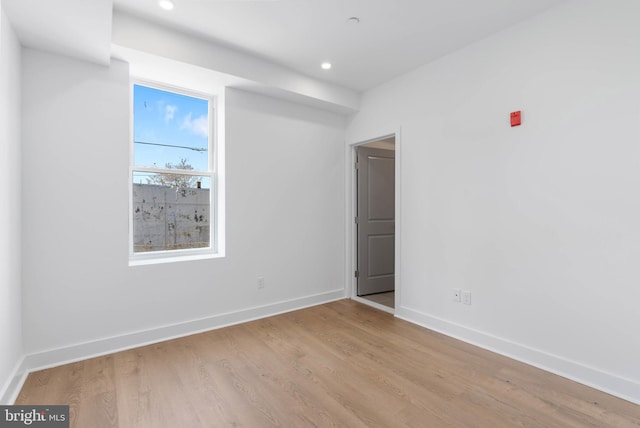 empty room featuring baseboards, recessed lighting, and light wood-style floors