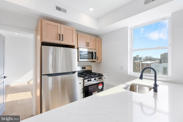 kitchen featuring recessed lighting, visible vents, appliances with stainless steel finishes, light brown cabinets, and a sink