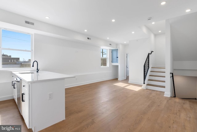 kitchen featuring light countertops, visible vents, white cabinetry, a sink, and dishwasher