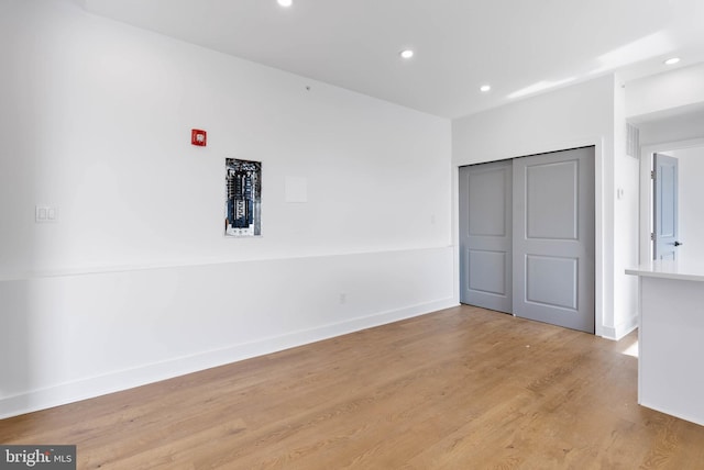 unfurnished bedroom with recessed lighting, a closet, baseboards, and light wood finished floors