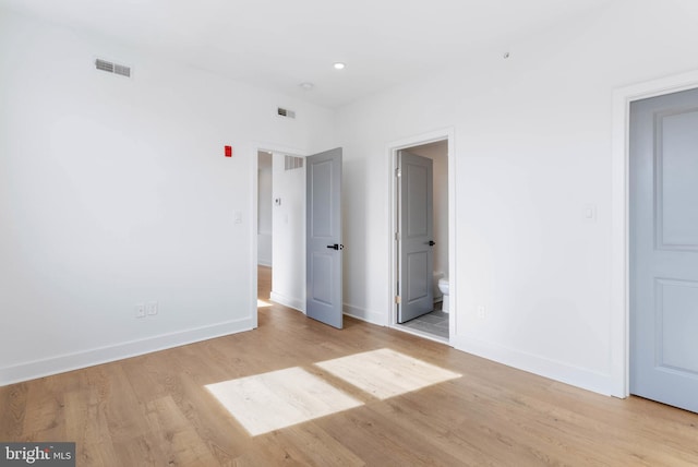 unfurnished bedroom with light wood-type flooring, visible vents, and baseboards