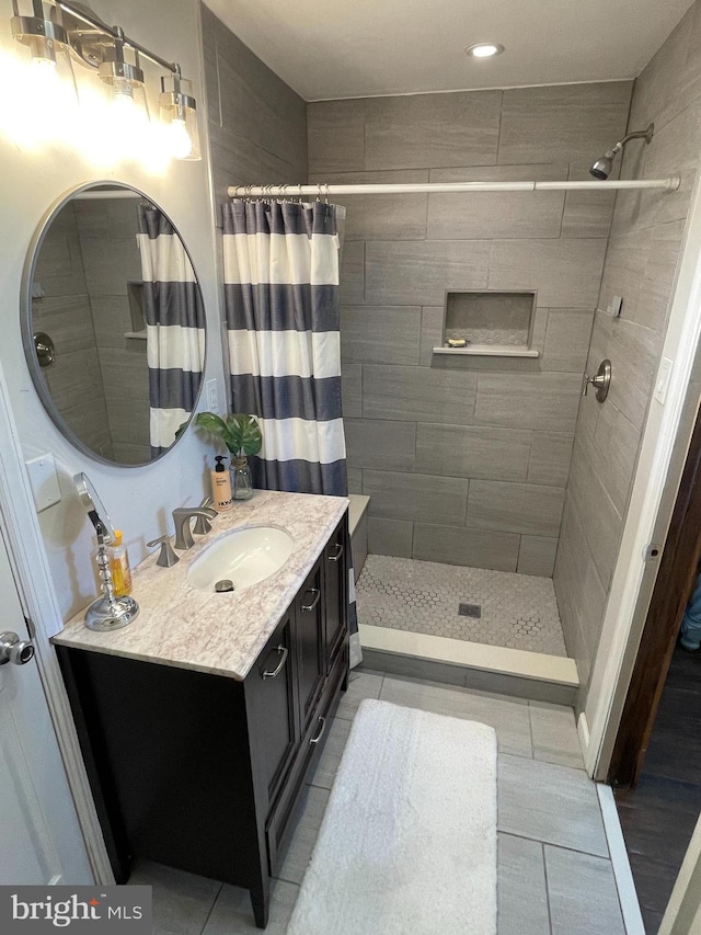 full bath with tile patterned flooring, vanity, and a shower stall