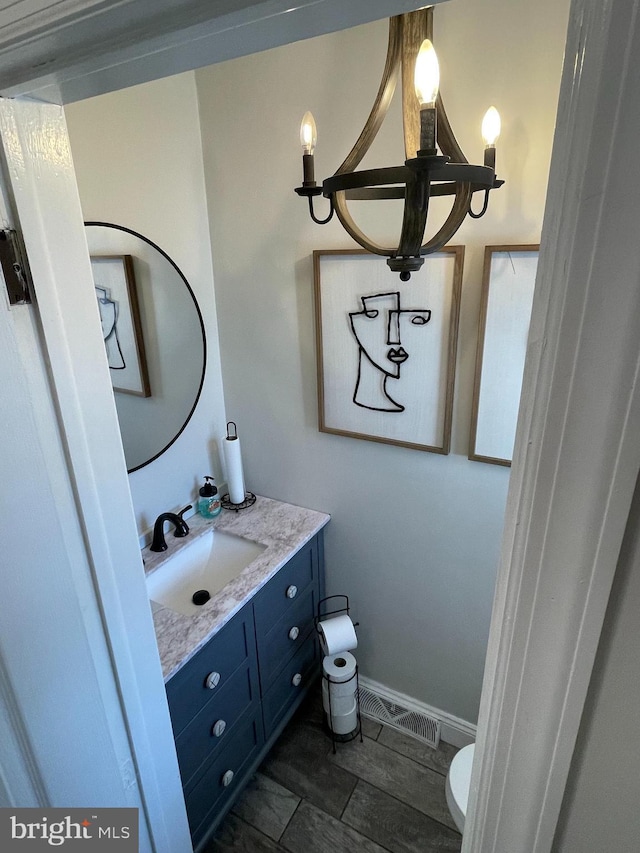 bathroom with visible vents, toilet, vanity, and baseboards