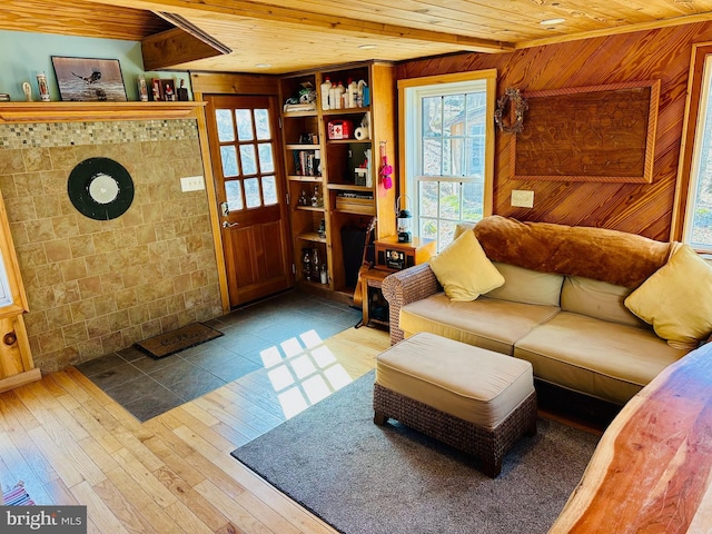 living room with wood finished floors, wood ceiling, and wooden walls