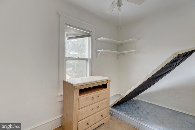 spacious closet featuring light carpet and a ceiling fan