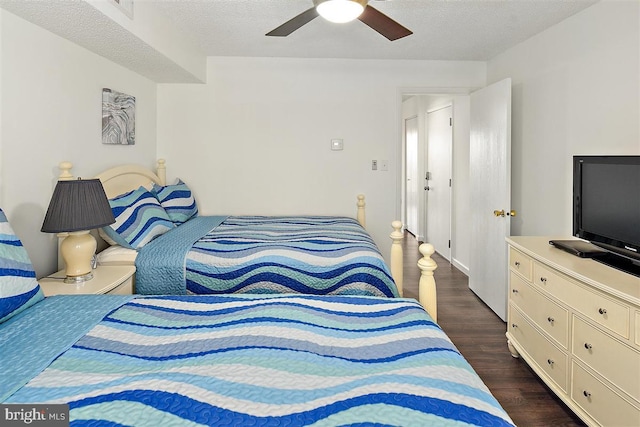 bedroom with dark wood-style floors, ceiling fan, and a textured ceiling