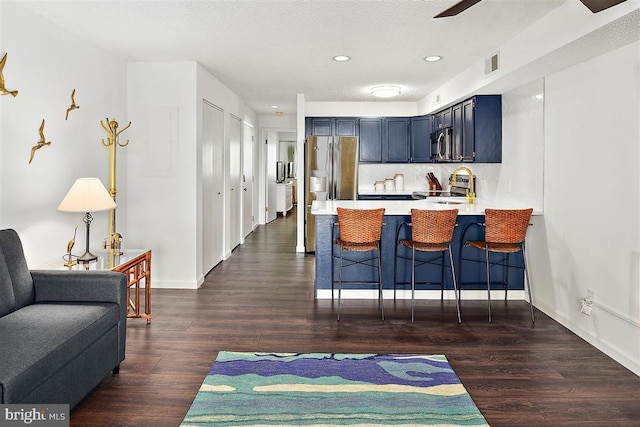 kitchen featuring a breakfast bar area, visible vents, light countertops, appliances with stainless steel finishes, and a peninsula