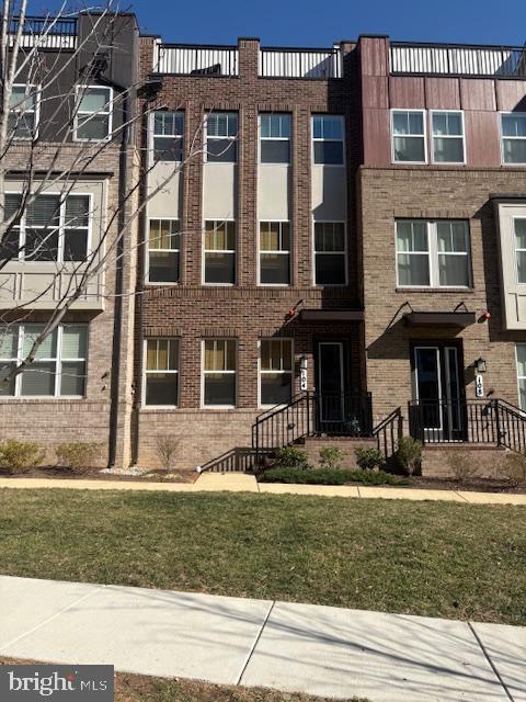 view of property with a front lawn and brick siding