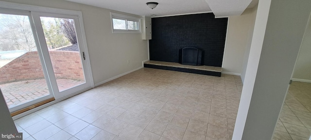 unfurnished living room featuring a fireplace and baseboards