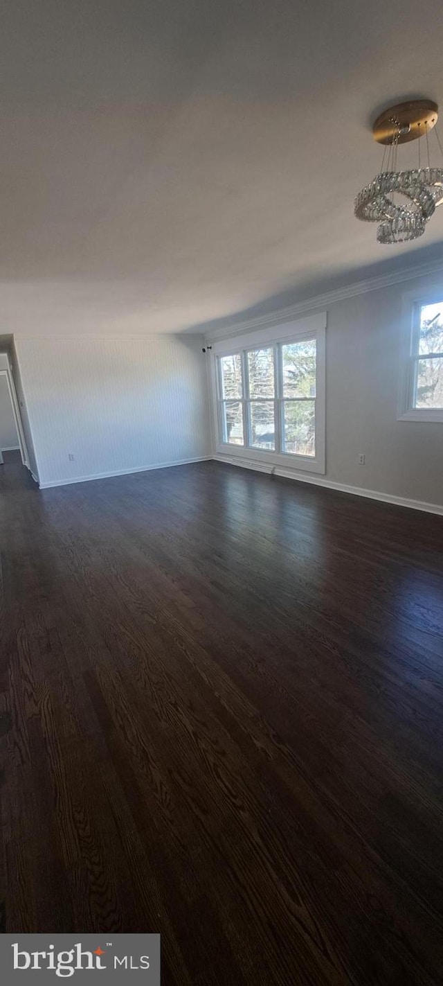 unfurnished room with dark wood finished floors and baseboards