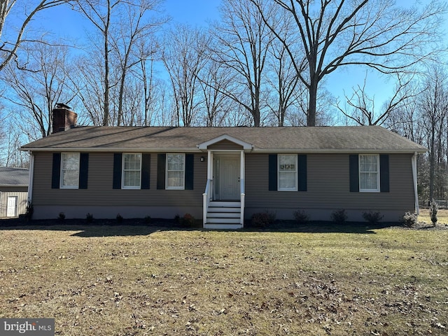 view of front of home with a chimney and a front yard