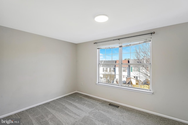 unfurnished room featuring carpet and baseboards