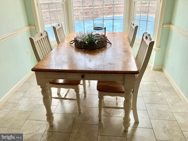 dining area featuring light tile patterned floors and baseboards