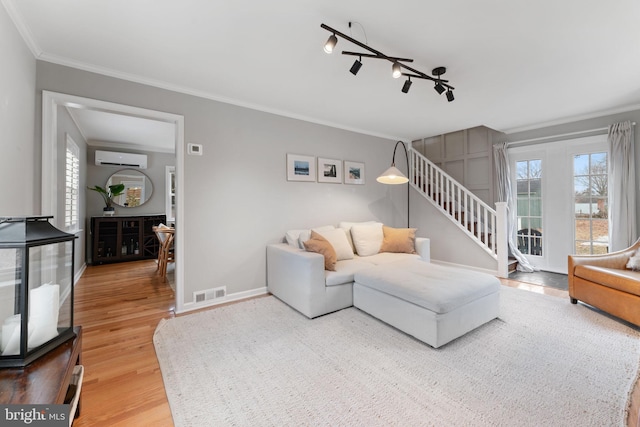 living room featuring crown molding, visible vents, stairway, an AC wall unit, and wood finished floors