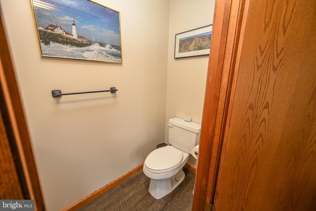 bathroom featuring wood finished floors, toilet, and baseboards