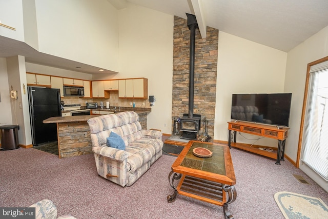 carpeted living area with a wood stove, high vaulted ceiling, baseboards, and beamed ceiling