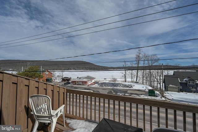 snow covered deck with a mountain view